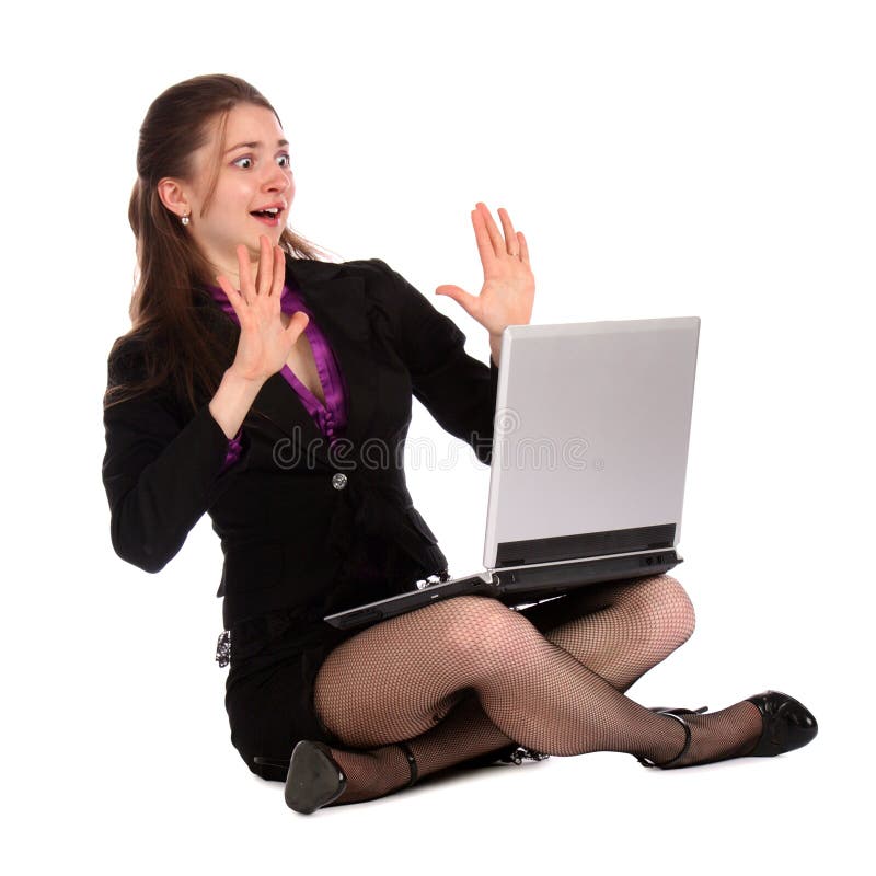 Shocked girl sits on floor with notebook.