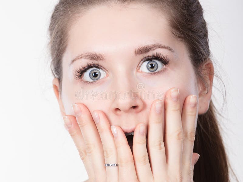 Shocked ha stupito la bocca della copertura della donna con le mani fotografia stock Shocked ha stupito la bocca della copertura della donna con le mani fotografia stock
