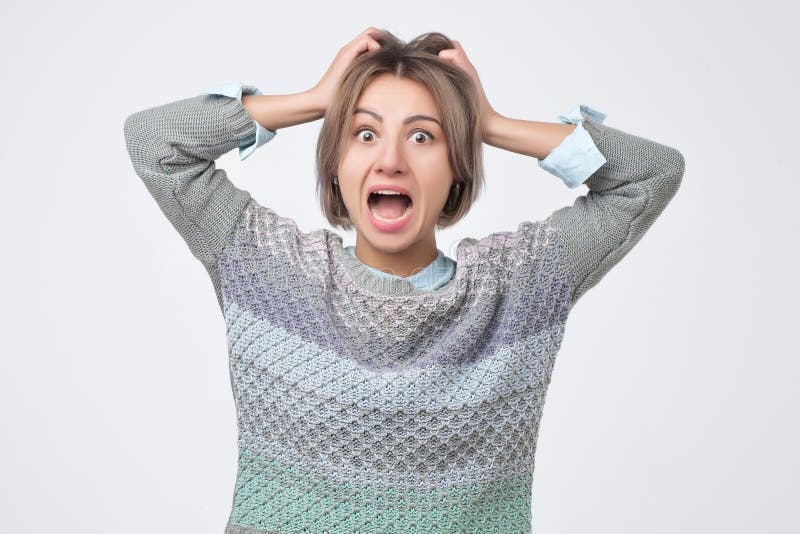 Shocked ha stupito la giovane donna con le mani sulla testa che sta e che grida immagini stock libere da diritti Shocked ha stupito la giovane donna con le mani sulla testa che sta e che grida immagini stock libere da diritti