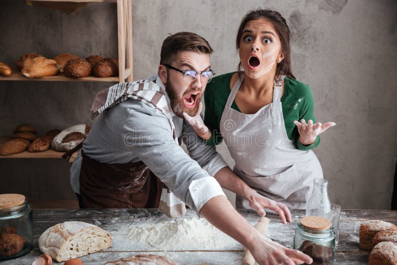 Shocked man and woman standing near table with flour royalty free stock images Shocked man and woman standing near table with flour royalty free stock images