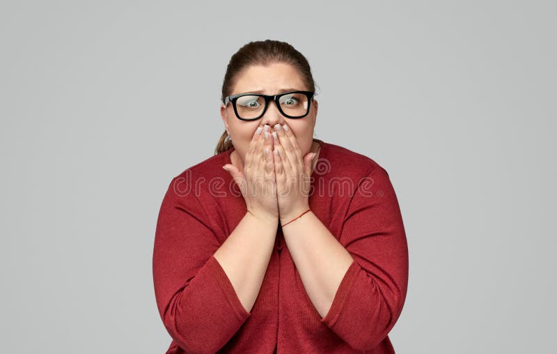 Shocked plump woman covering mouth