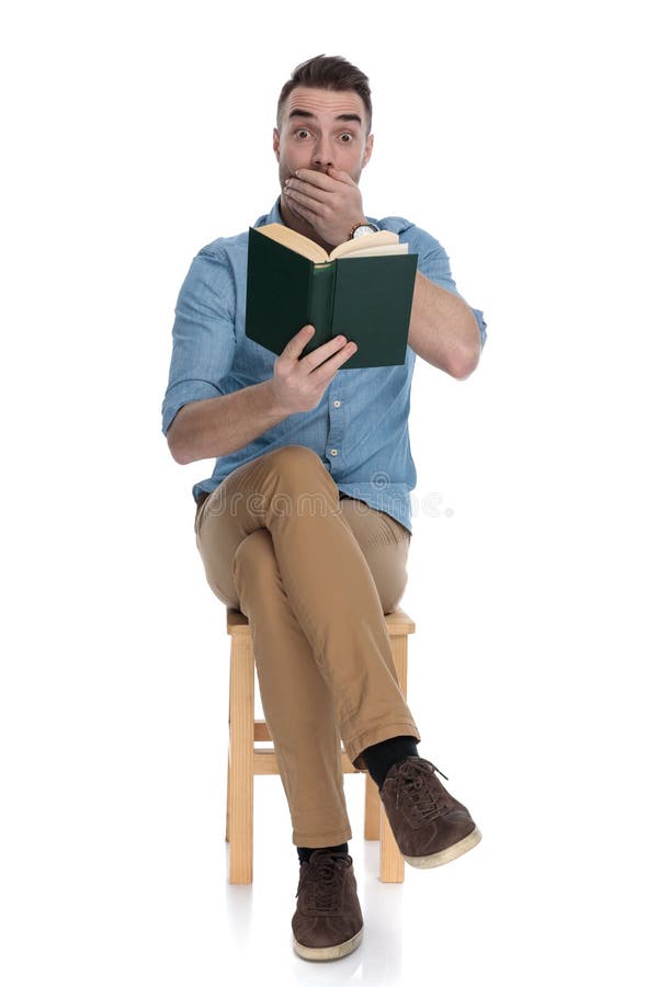 Shocked smart casual man reading a book and gasping royalty free stock photos