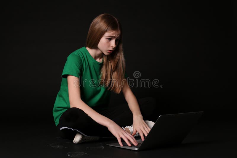 Shocked teenage girl with laptop on black background. Danger of internet. Shocked teenage girl with laptop on black background. Danger of internet