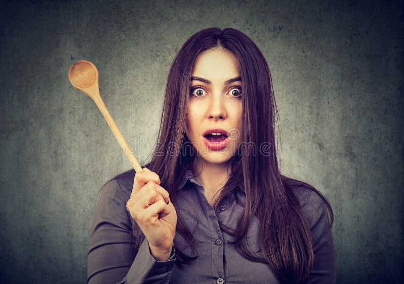 Shocked woman with cooking spoon