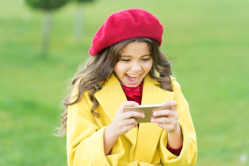 Shocking content. Little girl using mobile phone. Small girl child checking news feed. Surfing internet. Social networks stock photography Shocking content. Little girl using mobile phone. Small girl child checking news feed. Surfing internet. Social networks stock photography
