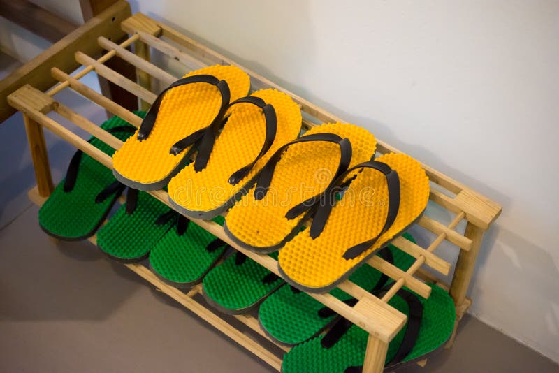 Shoe Rack with Yellow and Green Rubber Sandal or Slippers. Stock Photo Image of green