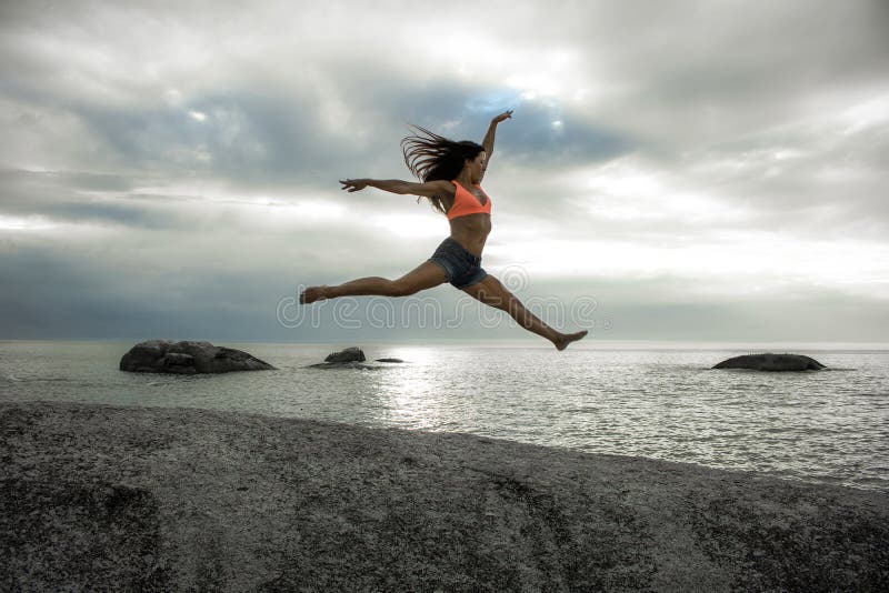 Woman Jumping On A Rock At Sunset On Bakovern Beach Cape Town Stock Image Image Of Overcast