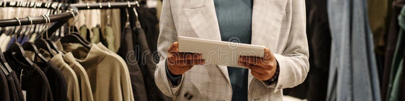 Shop assistant in blazer using tablet royalty free stock photo