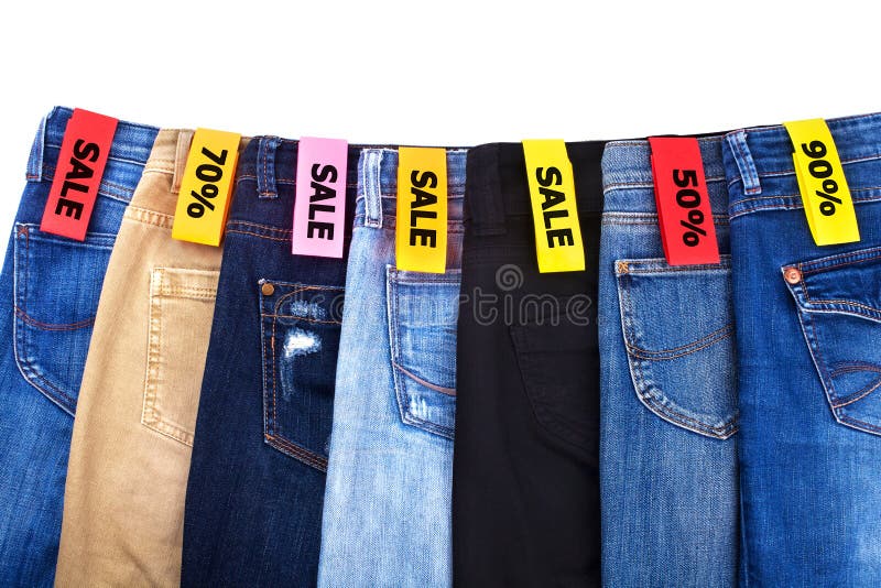 Shop sale of clothes, jeans of different colors blue, green, black on white background isolated close up