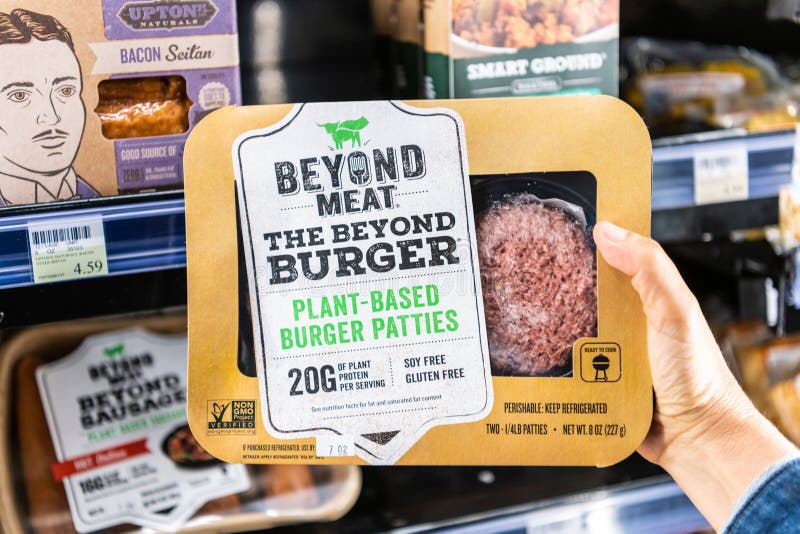 Shoppare räcker att rymma en packe av utöver köttmärkesväxten baserade hamburgaresmå pastejer royaltyfri bild