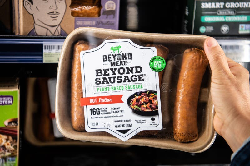 Shoppare räcker att rymma en packe av utöver köttmärkesväxten baserade varma italienska korvar royaltyfri foto