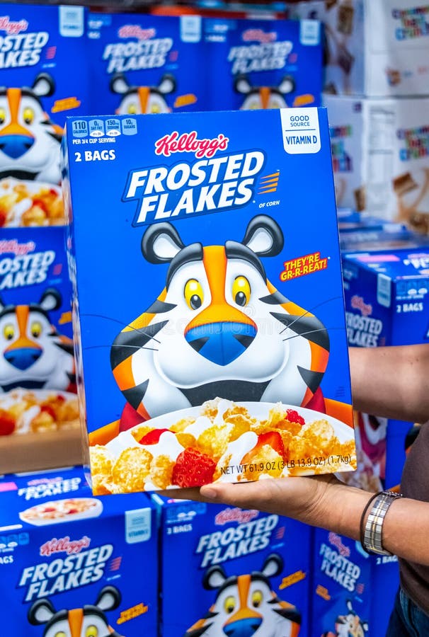 Shoppers hand holding a family size package of Kellogg`s brand Frosted Flakes cereal