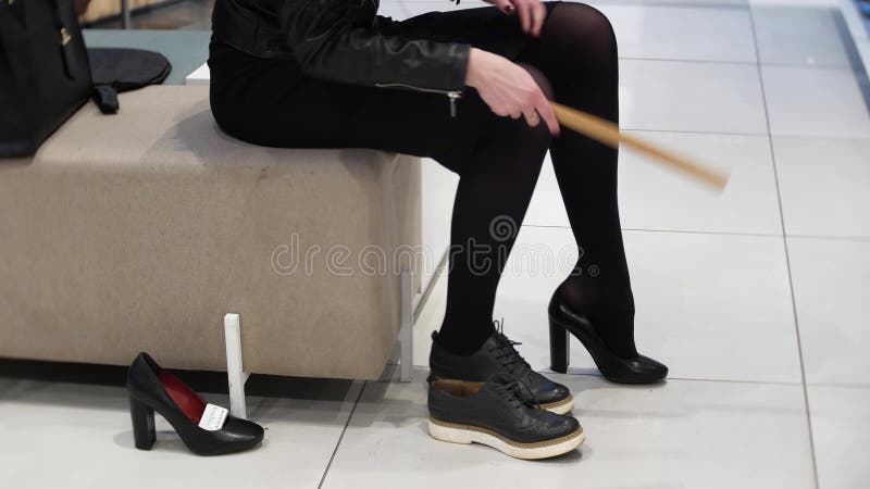 Shopping concept - Young Woman Trying On High Heels In Shoe Store. Sexy legs. 4K cinematic