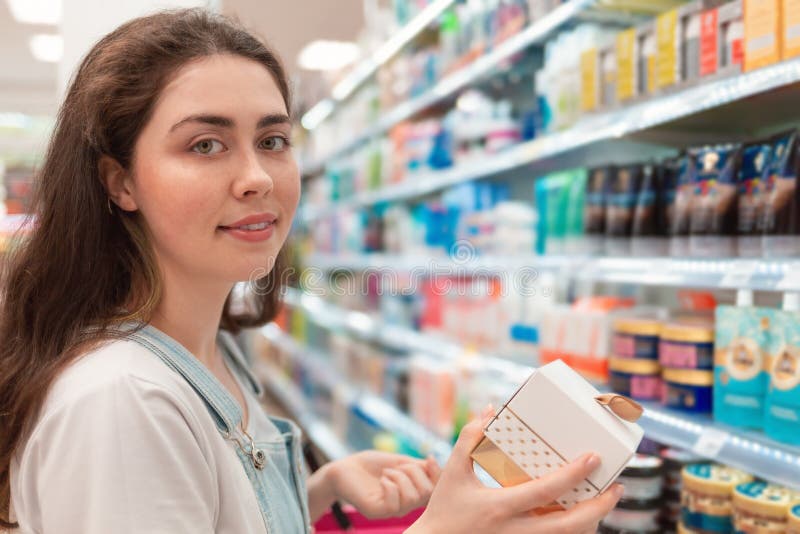 shopping Den unga härliga kvinnan ler och väljer skönhetsmedel som en gåva royaltyfria bilder shopping Den unga härliga kvinnan ler och väljer skönhetsmedel som en gåva royaltyfria bilder