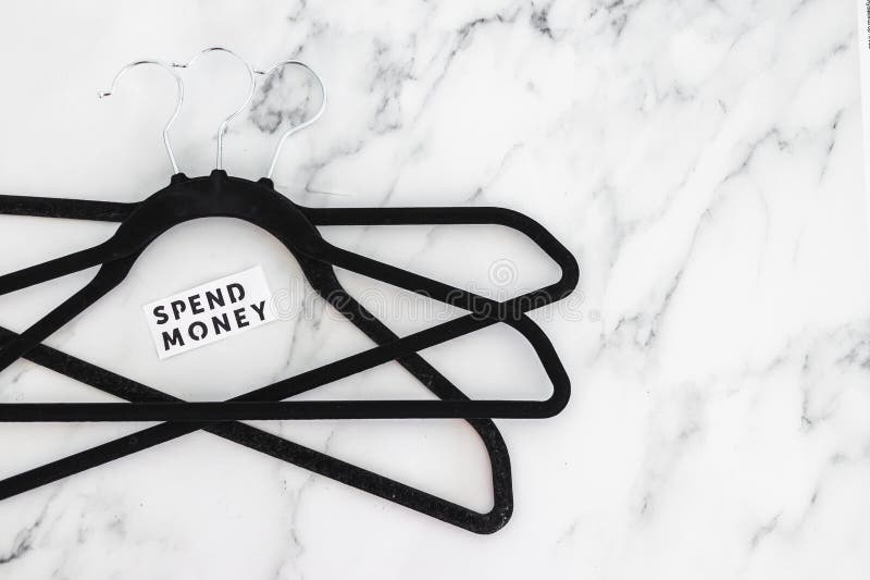 Shopping and purchasing power, group of clothes hangers with Spend Money text in the middle concept of buyers reducing their stock photo Shopping and purchasing power, group of clothes hangers with Spend Money text in the middle concept of buyers reducing their stock photo