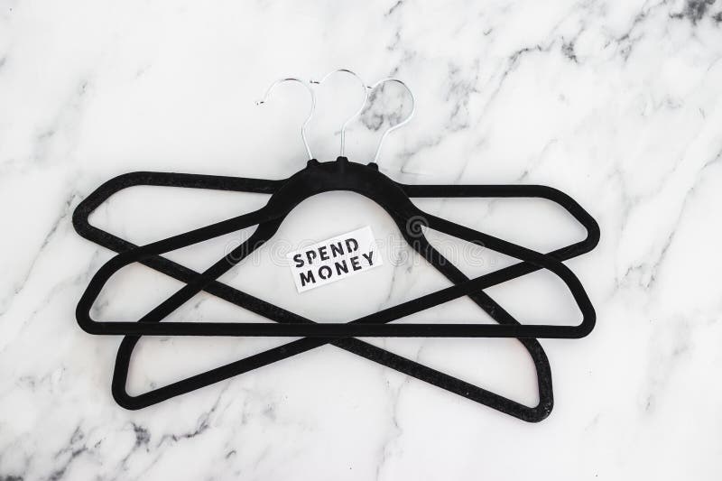 Shopping and purchasing power, group of clothes hangers with Spend Money text in the middle concept of buyers reducing their royalty free stock images Shopping and purchasing power, group of clothes hangers with Spend Money text in the middle concept of buyers reducing their royalty free stock images