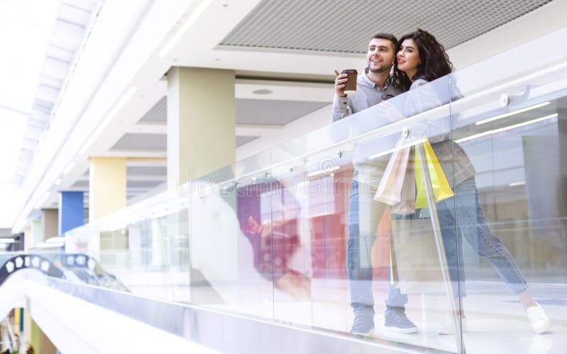 Shopping together. Young spouses resting in mall stock photos Shopping together. Young spouses resting in mall stock photos