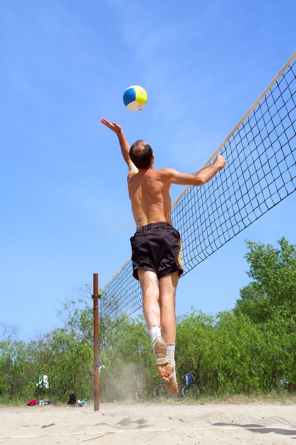 Short balding man hits ball