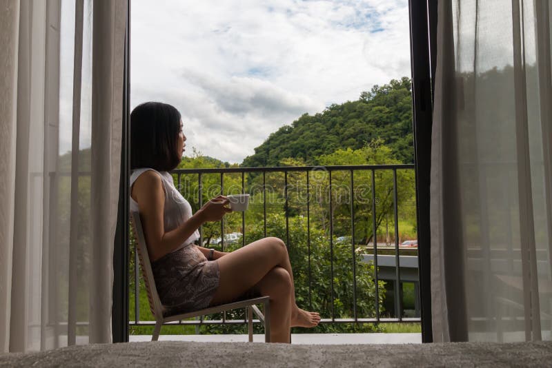 A short hair young woman sitting at the balcony. 