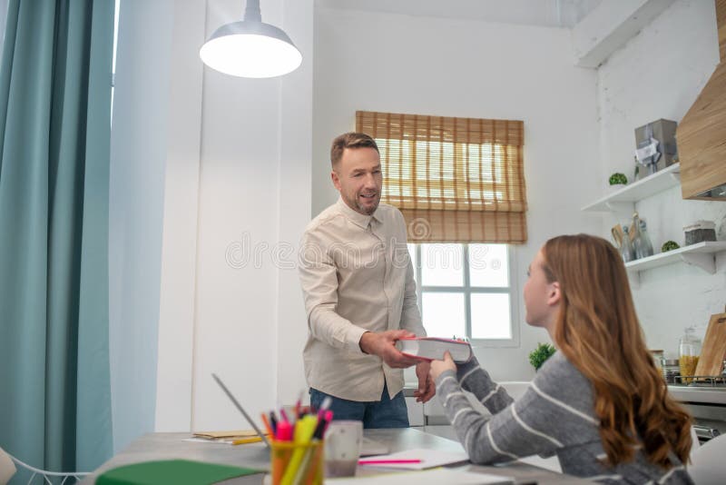 Short-haired bearded man giving a book to his student stock photos