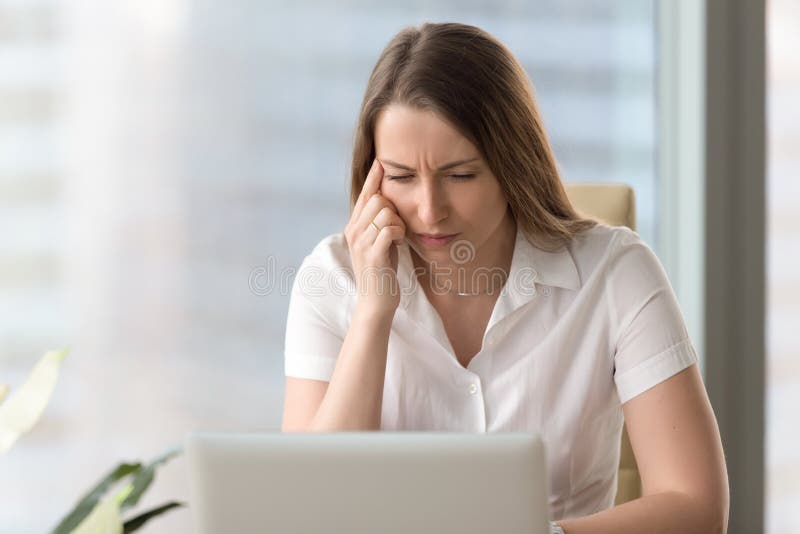 Shortsighted businesswoman squinting eyes looking at laptop scre