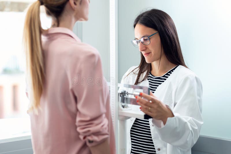 Female Nutritionist Weighing Patient On Biometric Scale During Medical  Consultation Stock Photo - Download Image Now - iStock