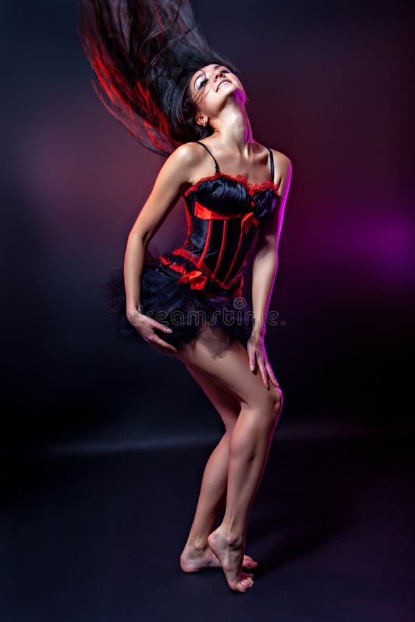 Shot of a dancing woman in elegant red-black corset