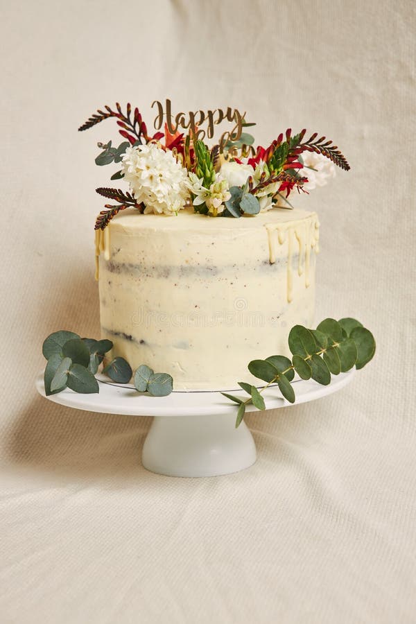 Shot of a delicious birthday white cream flowers on the top cake with a drip on the side stock photo Shot of a delicious birthday white cream flowers on the top cake with a drip on the side stock photo