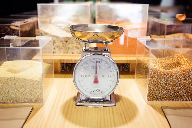 Food weighing machine and different types of condiments in bulk in an organic store. stock images