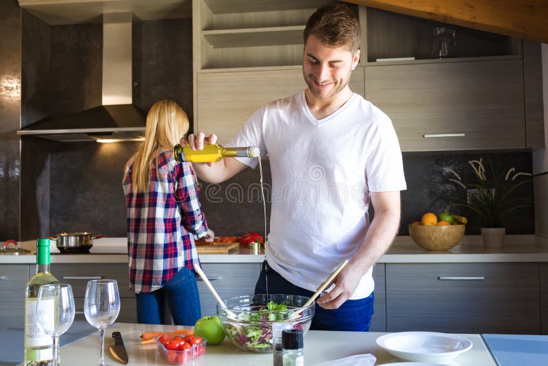Happy young couple cooking together in the kitchen at home. royalty free stock photo Happy young couple cooking together in the kitchen at home. royalty free stock photo