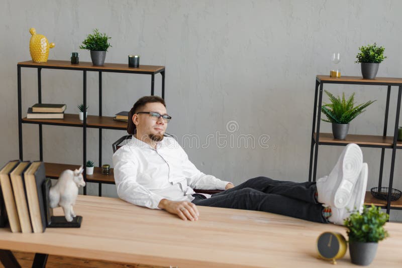 Shot om ung man som sitter vid bordet och tittar bort och tänker arkivbilder Shot om ung man som sitter vid bordet och tittar bort och tänker arkivbilder