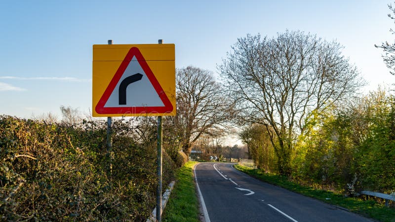 Dangerous turns, triangle warning traffic sign near rural road Stock Photo  - Alamy