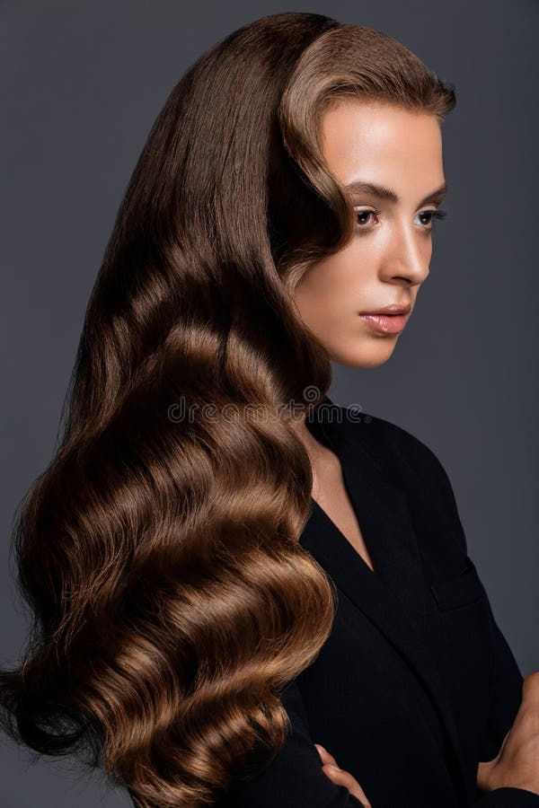 Shot of a woman with long glossy curly hairstyle stock photography