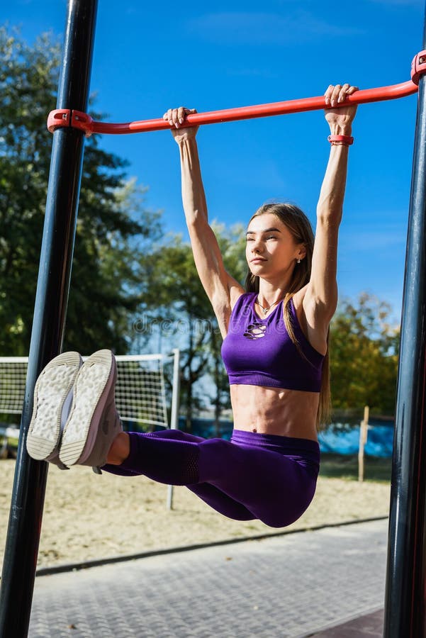 Shot of Young Woman Exercising on Wall Bars. Fitness Woman Exercising ...