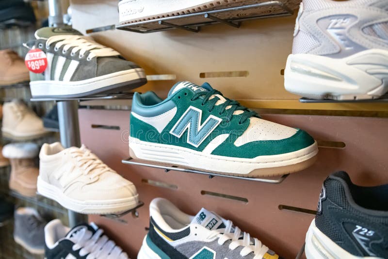 Showcase mit neuen Saldo-Sneakers in einem Fachgeschäft. großes Sortiment und Auswahl an Markenschuhen mit nb Logo stockfotos