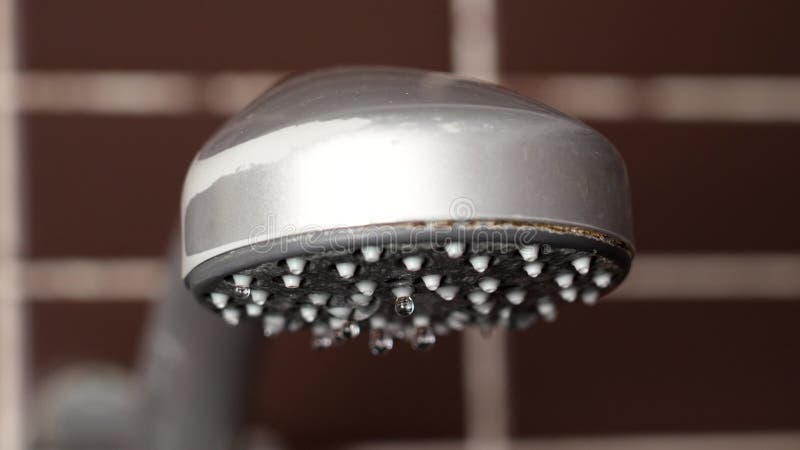 Shower head dripping water due to water shortage in hotel room