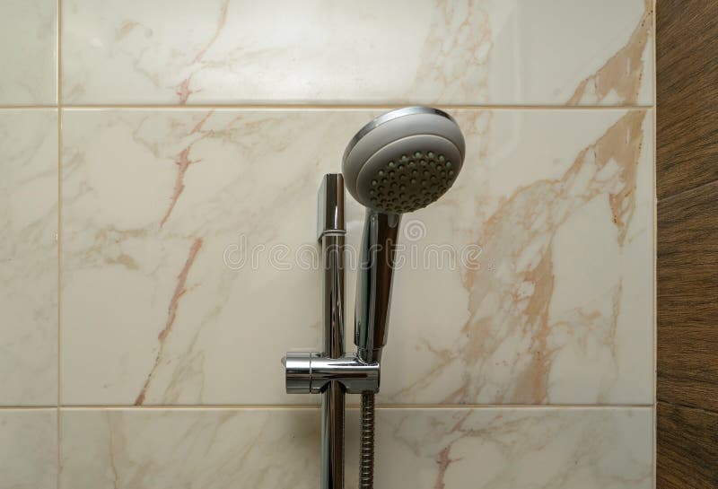 The Shower Head is Fixed on the Wall of Ceramic Tiles. Metal Shower