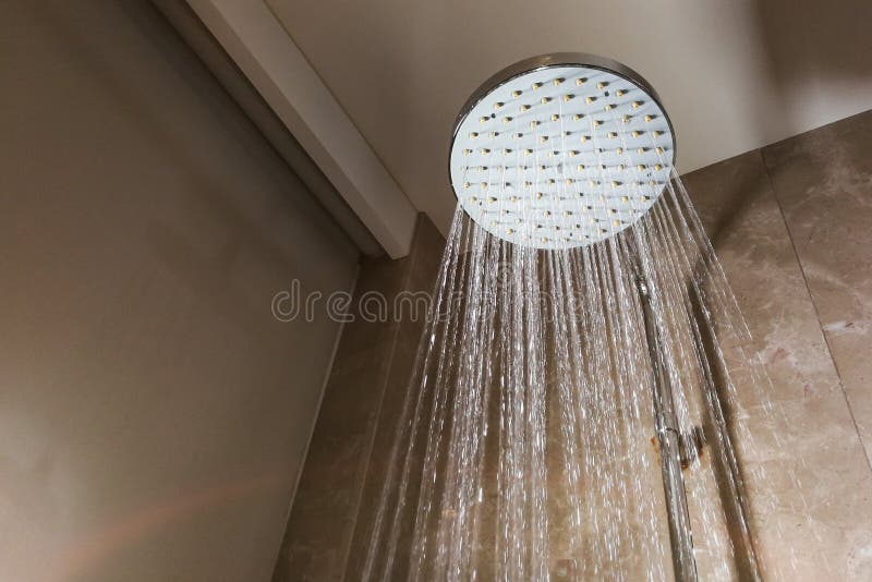 Shower Head with Refreshing Water Droplets Spraying Down in Bath Stock