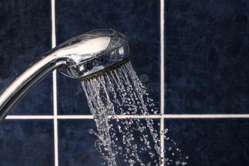 Shower Head on Tiled Background with Stream of Water Drops Flying Out