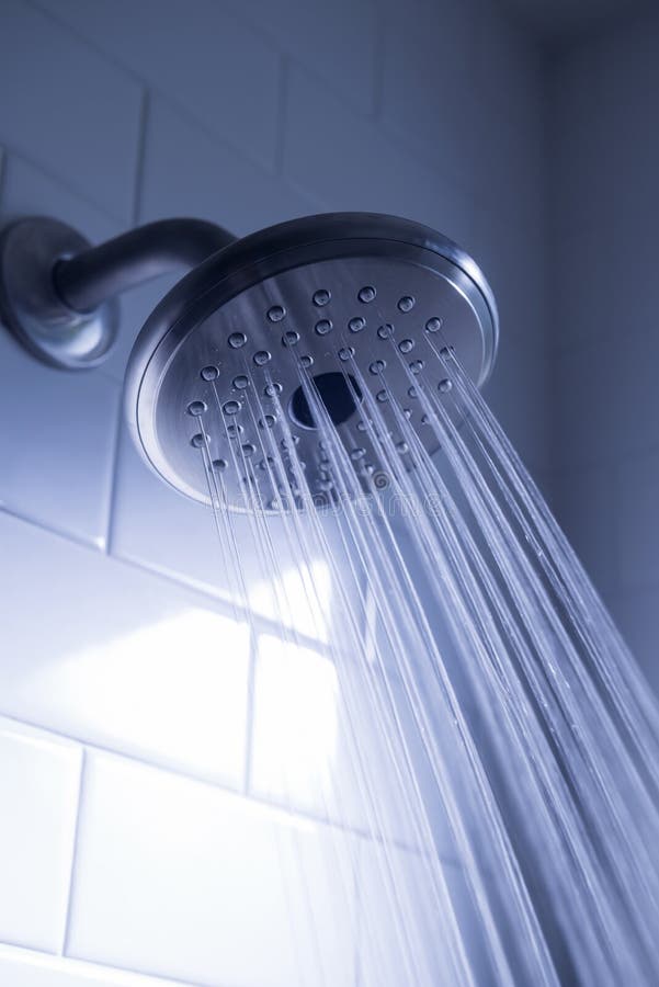 Shower head with water stream on blue background