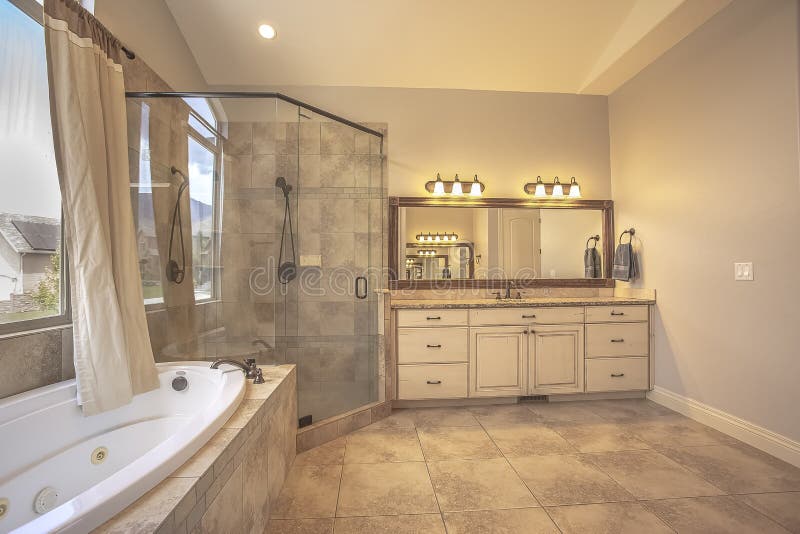 Shower Stall Beside An Oval Bathtub In Front Of An Arched Window With