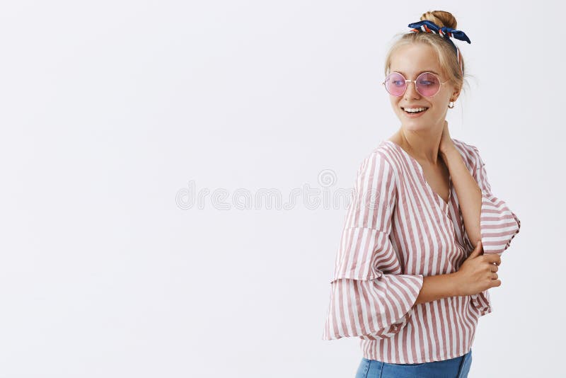 Showing how style works. Portrait of good-looking relaxed and cute woman with blond hair in stylish pink sunglasses and