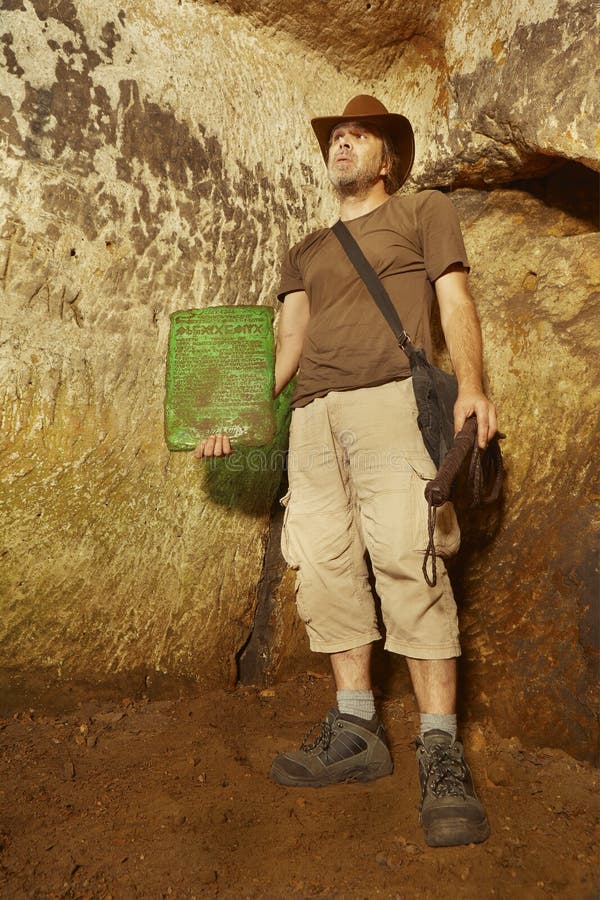Showing of tabula smaragdina in abandoned cave sanctuary. Adventurer in ancient cave finally found mysterious artifact emerald tablet