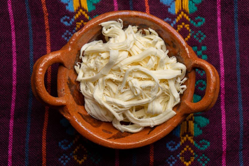 Shredded Oaxaca Cheese Also Called Quesillo on Rustic Background