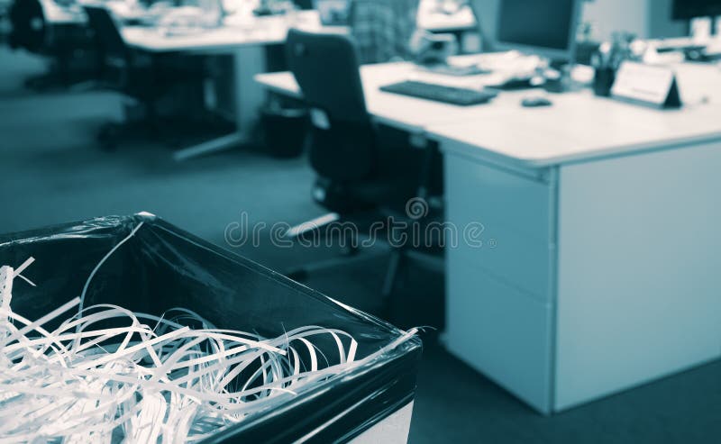 Shredded paper in a bin with blurred open space modern office in background - Documents destroyed by company staff during royalty free stock photo Shredded paper in a bin with blurred open space modern office in background - Documents destroyed by company staff during royalty free stock photo
