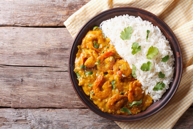 Shrimps in curry sauce and rice on a plate. horizontal view from above. Shrimps in curry sauce and rice on a plate. horizontal view from above