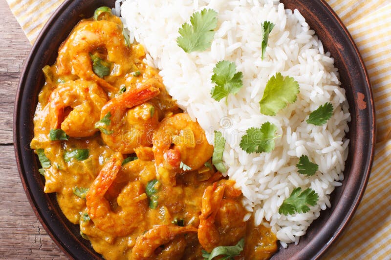 Shrimps in curry sauce and rice on a plate close-up. horizontal view from above. Shrimps in curry sauce and rice on a plate close-up. horizontal view from above