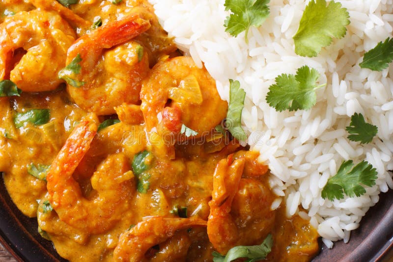 Shrimps in curry sauce and rice on a plate macro. horizontal view from above. Shrimps in curry sauce and rice on a plate macro. horizontal view from above