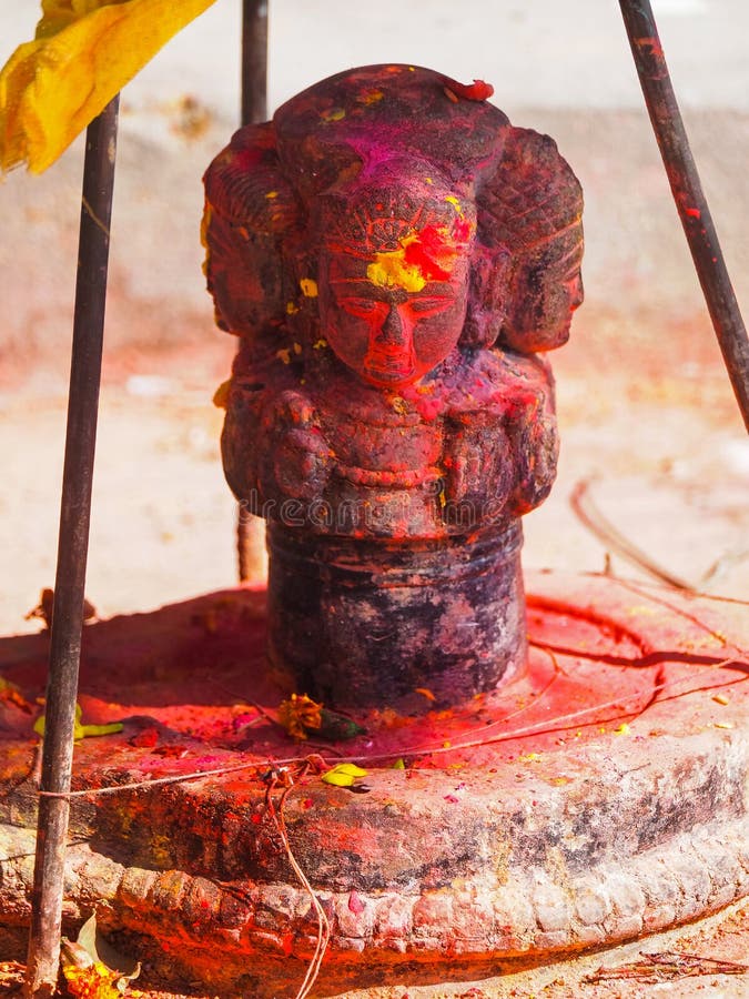 Shrine covered in vermillion to worship Goddess Kali. Red pigment powder on statue in Dhulikhel, Nepal