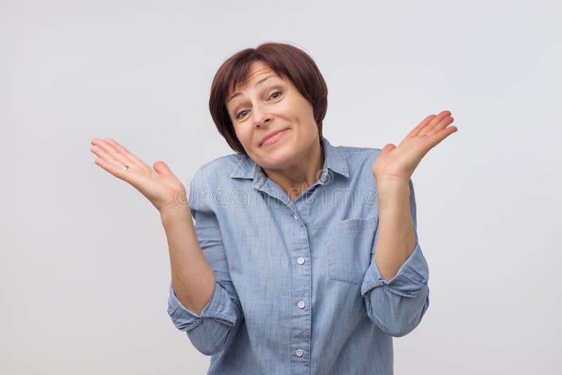Shrugging mature woman in doubt looking at camera royalty free stock photos Shrugging mature woman in doubt looking at camera royalty free stock photos